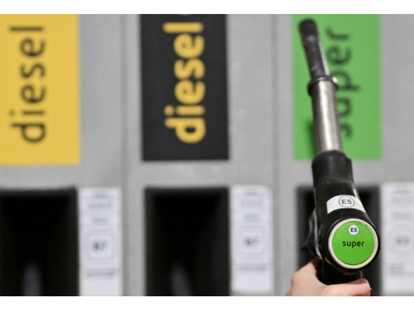 A person holds a petrol pump to fill up the car with gazole at an Eni petrol station near Monza, northern Italy on March 11, 2026. (Photo by Stefano Rellandini / AFP)