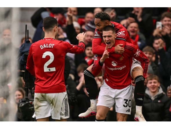 Manchester United's Slovenian striker #30 Benjamin Sesko (R) celebrates with Manchester United's Brazilian striker #10 Matheus Cunha (top R) and teammates after scoring his team's third goal during the English Premier League football match between Manchester United and Aston Villa at Old Trafford in Manchester, north west England, on March 15, 2026. (Photo by Oli SCARFF / AFP)