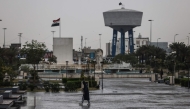 An Iraqi man walks through Al-Umma Park during rainfall in Baghdad on March 15, 2026. (Photo by AHMAD AL-RUBAYE / AFP)
