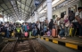 Passengers prepare to board a train to return home ahead of Eid al-Fitr, at Gubeng station in Surabaya on March 17, 2026. (Photo by Juni Kriswanto / AFP)