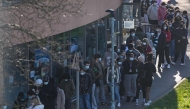 Students wearing face masks queue up to get vaccinated at the University of Kent in Canterbury, south-east England on March 18, 2026, following an outbreak of meningitis. Photo by CARLOS JASSO / AFP