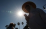 A person wears a hat for shade under the morning sun while walking along The Strand in Redondo Beach, California on March 20, 2026, during a heat wave. (Photo by Patrick T. Fallon / AFP)