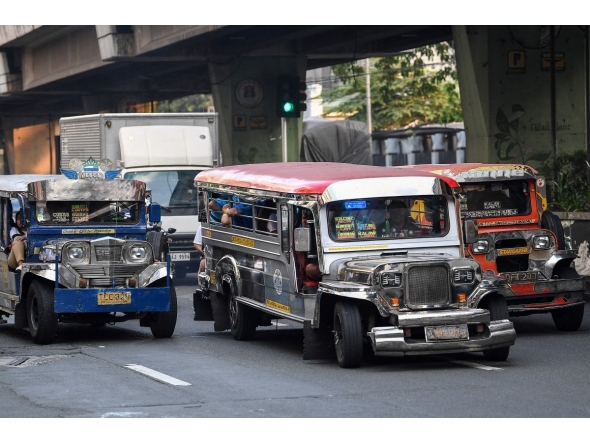 Jeepneys ply their route along a street in Manila on March 23, 2026.Photo by Ted ALJIBE / AFP