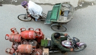 A delivery man transports liquid petroleum gas (LPG) cylinders in Amritsar on March 24, 2026. Photo by Narinder Nanu / AFP

