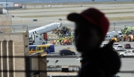 A child looks out at an Air Canada Express plane that collided Sunday night with a fire truck on the tarmac at LaGuardia Airport on March 25, 2026 in New York City. Photo by SPENCER PLATT / GETTY IMAGES NORTH AMERICA / Getty Images via AFP