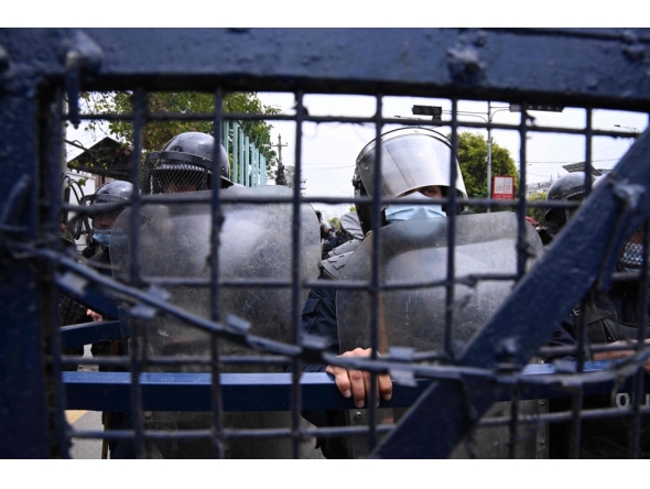 Police stand guard while Nepali former prime minister KP Sharma Oli's supporters protest against his arrest in Kathmandu on March 29, 2026. (Photo by Prakash Mathema / AFP)