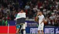 Iraq's forward #09 Ali Al-Hamadi (L) comforts Bolivia's forward #11 Fernando Nava (C) after the 2026 FIFA World Cup qualifiers final playoff football match between Iraq and Bolivia at the BBVA Stadium in Guadalupe, Nuevo Leon state, Mexico (Photo by Julio Cesar Aguilar / AFP)