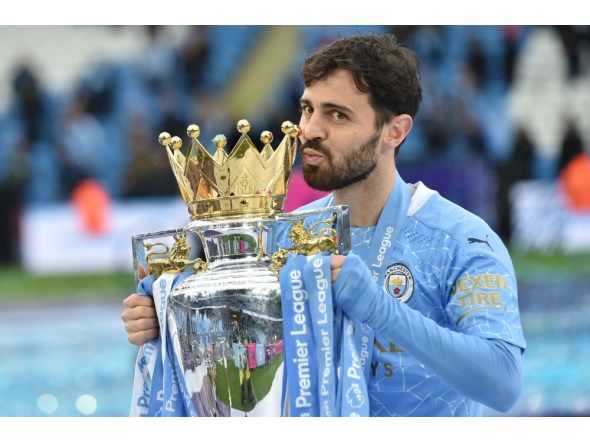 (Files) Manchester City's Portuguese midfielder Bernardo Silva lifts the Premier League trophy in Manchester, north west England, on May 23, 2021. (Photo by Peter Powell / Pool / AFP)