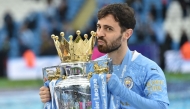 (Files) Manchester City's Portuguese midfielder Bernardo Silva lifts the Premier League trophy in Manchester, north west England, on May 23, 2021. (Photo by Peter Powell / Pool / AFP)