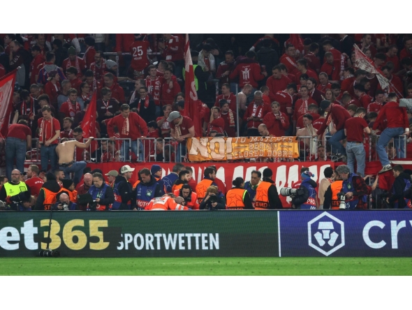 A photographer is treated after fans climbed over the fence after the UEFA Champions League quarter-final second leg football match between FC Bayern Munich and Real Madrid in Munich, southern Germany, on April 15, 2026. Photo by Karl-Josef HILDENBRAND / AFP