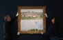 (FILES) Employees of the Sotheby's auction house handle the painting 