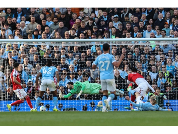 Manchester City's Norwegian striker #09 Erling Haaland (front R) shoots to score his team's second goal during the English Premier League football match between Manchester City and Arsenal at the Etihad Stadium in Manchester, north west England, on April 19, 2026. (Photo by Darren Staples / AFP)