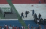 Fans of Cerro Porteno clash with police officers during the Paraguayan tournament football match between Olimpia and Cerro Porteno at the Defensores del Chaco stadium in Asuncion on April 19, 2026. (Photo by Daniel Duarte / AFP)
