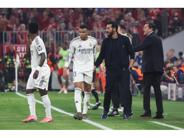 Real Madrid's Spanish coach Alvaro Arbeloa (2nd R) and Real Madrid's French forward #10 Kylian Mbappe (2nd L) are seen on the sidelines during the UEFA Champions League quarter-final second leg football match between FC Bayern Munich and Real Madrid in Munich, southern Germany, on April 15, 2026. (Photo by Karl-Josef HILDENBRAND / AFP)