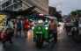 A tuk tuk drives past fruit stalls at Mahanak Market in Bangkok. (Photo by Anthony Wallace/ AFP)