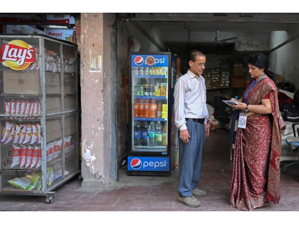 Sukhwinder Kaur (R), a census enumerator and a school teacher, collects details of housing and amenities during a door-to-door survey in the first phase of the census at a residential area in New Delhi on April 20, 2026. (Photo by Arun Sankar / AFP)