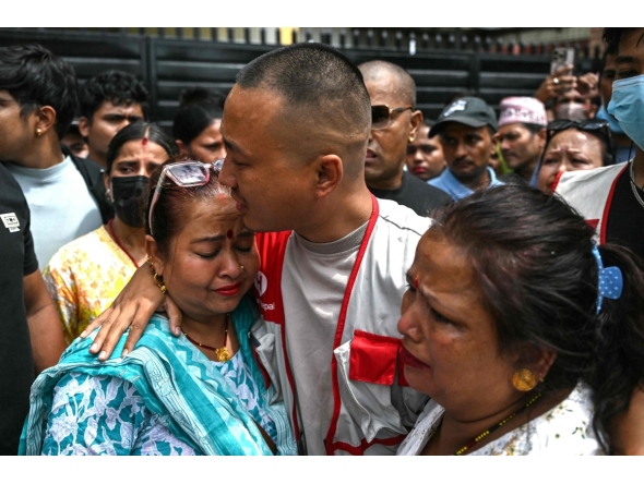 Sudan Gurung (C), a key figure among the Gen Z protesters, meets with family members of a victim, who died during anti-corruption clashes with security personnel, outside the Tribhuvan University Teaching Hospital in Kathmandu on September 13, 2025. Photo by Arun SANKAR / AFP