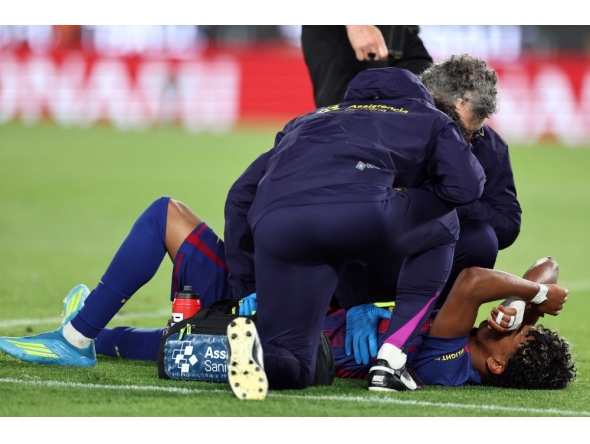 Barcelona's Spanish forward #10 Lamine Yamal receives medical attention after sustaining an injury during the Spanish league football match between FC Barcelona and RC Celta de Vigo at Camp Nou stadium in Barcelona on April 22, 2026. (Photo by Josep Lago / AFP)