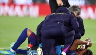 Barcelona's Spanish forward #10 Lamine Yamal receives medical attention after sustaining an injury during the Spanish league football match between FC Barcelona and RC Celta de Vigo at Camp Nou stadium in Barcelona on April 22, 2026. (Photo by Josep Lago / AFP)