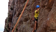 This photograph taken on March 28, 2026 shows a climber scaling a rock wall during a rock climbing festival at a sandstone cliffs site in Karnataka's Badami town. (Photo by Sajjad Hussain / AFP)