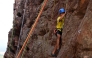 This photograph taken on March 28, 2026 shows a climber scaling a rock wall during a rock climbing festival at a sandstone cliffs site in Karnataka's Badami town. (Photo by Sajjad Hussain / AFP)