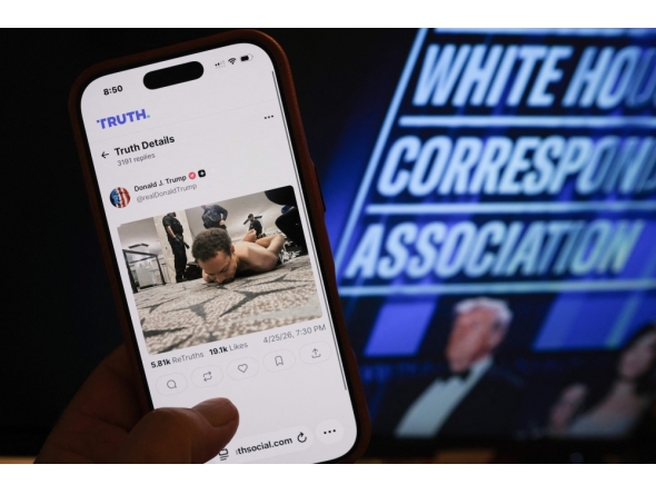 This illustration photo taken in Los Angeles shows a phone with a Truth Social post by US President Donald Trump displaying an image of the alleged suspect in a shooting incident at the White House Correspondents’ Dinner on the ground after being apprehended on April 25, 2026. (Photo by Chris Delmas / AFP)