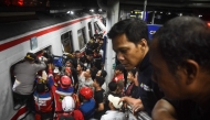 Rescuers work at the site of a train collision after a passenger train locomotive pierced through the rear car of a commuter train at Bekasi Timur station in Bekasi, West Java on April 28, 2026. (Photo by Rezas / AFP)