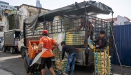 Workers unload sacks of rice outside a market in Kuala Lumpur on April 28, 2026. (Photo by Mohd Rasfan / AFP)