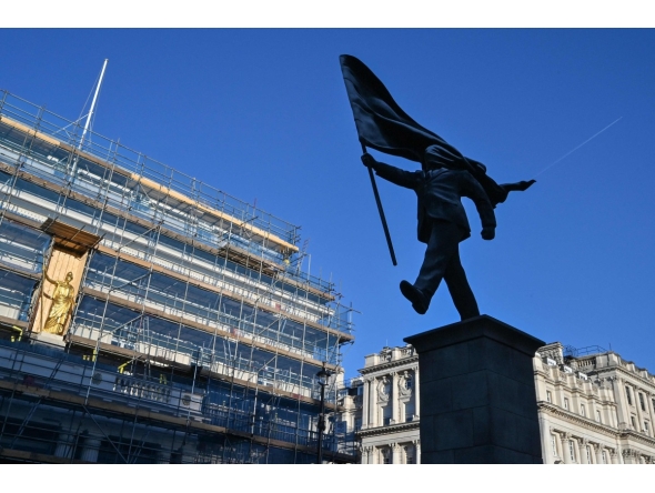 A statue (R) which suddenly appeared the day before, bearing the signature of British street artist Banksy etched onto its base, is pictured in Waterloo Place in central London early morning on April 30, 2026. Photo by Richard A. Brooks / AFP