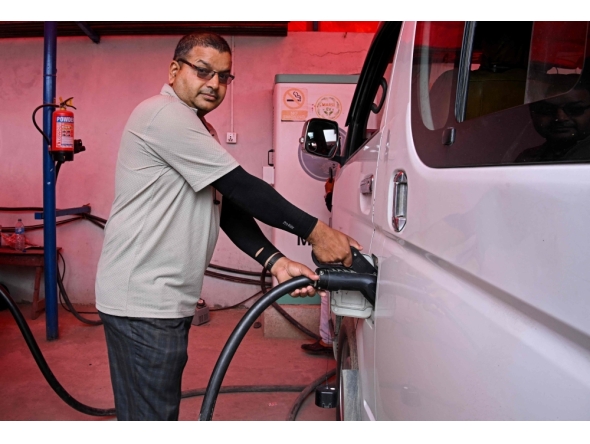 NEPAL-TRANSPORT-AUTOMOBILE-ENERGY
Electric microbus driver Purushottam Adhikari charges his vehicle at a charging station in Kathmandu on May 1, 2026. As global fuel markets reel from the Middle East war, motorists in Nepal are increasingly turning to electric vehicles, with high demand putting a strain on dealerships. 
(Photo by Prakash MATHEMA / AFP) / TO GO WITH 'Nepal-Transport-Automobile-Energy' FOCUS