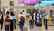 (FILES) A picture shows passengers walking towards the gates at terminal 3 at Dubai international Airport, in the Gulf emirate of Dubai, on August 16, 2022.
(Photo by Giuseppe Cacace / AFP)