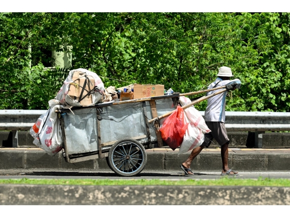 A door-to-door waste collector pushes his cart in front of a house in Jakarta on May 4, 2026. (Photo by Bay Ismoyo / AFP)
