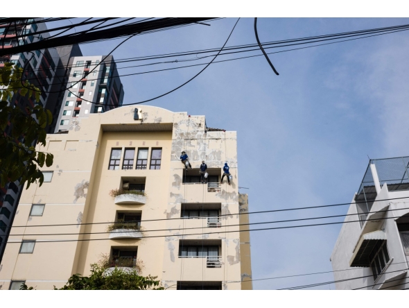 Workers repair the exterior of a building in Bangkok on May 8, 2026. (Photo by ANTHONY WALLACE / AFP)