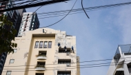Workers repair the exterior of a building in Bangkok on May 8, 2026. (Photo by ANTHONY WALLACE / AFP)