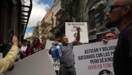 Dockers hold banners reading 'Without protocol, no safety' as they protest against the arrival of a cruise ship affected by hantavirus in Santa Cruz de Tenerife on May 8, 2026. Photo by JORGE GUERRERO / AFP
