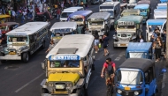 In this photo taken on April 5, 2024, jeepneys commute along a street in Manila. (Photo by Ted ALJIBE / AFP)