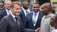 France's President Emmanuel Macron (L) speaks with Kenya's Sabastian Sawe (2nd R), the first man to run under two hours for a marathon in race conditions at a sport demonstration during the Africa Forward summit in Nairobi on May 11, 2026. (Photo by Ludovic Marin / AFP)
