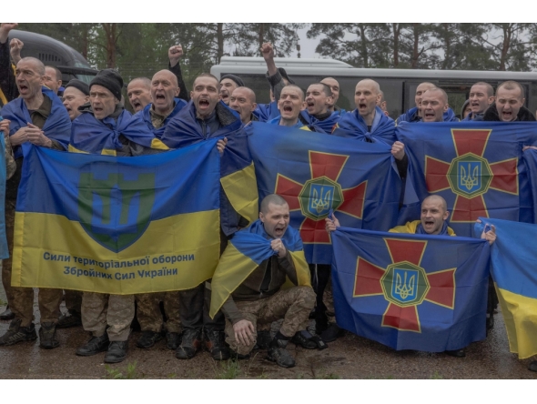 Released Ukrainian prisoners of war (POWs) react as they pose for a group photograph following a prisoner exchange at an undisclosed location, in the Chernihiv region on May 15, 2026. (Photo by Roman PILIPEY / AFP)