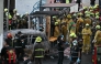 Forensic police officers, rescue workers and firefighters stand at the site of a train collision with a bus underneath Makkasan Airport Rail station in Bangkok on May 16, 2026. (Photo by Lillian SUWANRUMPHA / AFP)