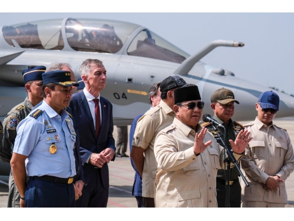 Indonesian President Prabowo Subianto (front) delivers a statement to journalists during a ceremony to hand over six new Rafale jet fighters, four Dassault Falcon 8X aircrafts and one Airbus A400M Atlas aircraft to the Indonesian Air Force at Halim Perdanakusuma Air Force Base in Jakarta.. (Photo by Bay Ismoyo / AFP)