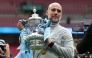 Manchester City's Spanish manager Pep Guardiola poses with the trophy on the pitch after the English FA Cup final football match between Chelsea and Manchester City at Wembley stadium in London, on May 16, 2026. Photo by ADRIAN DENNIS / AFP