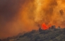 Fire fighters use a bulldozer to combat the Sandy Fire as it burns on a hill at a residential area in Simi Valley, California (Photo by Apu Gomes / AFP)