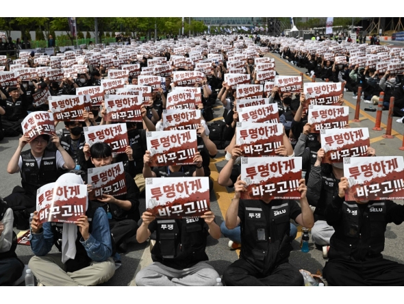 Members of the Samsung Electronics labour union hold signs reading 