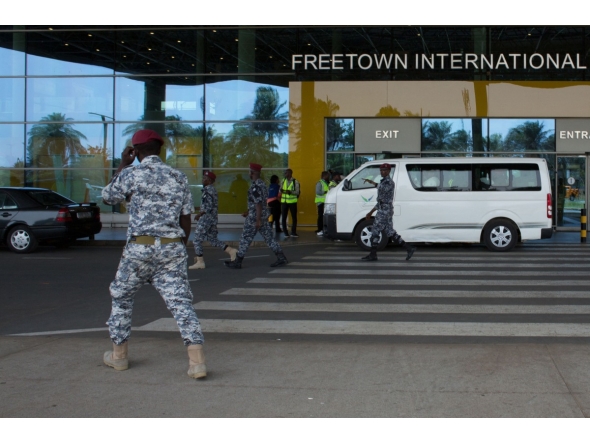 Security escort migrants in a National Public Health Agency (NPHA) after their arrival at Freetown International Airport, formerly known as Lungi International Airport, in Lungi on May 20, 2026. (Photo by AFP)