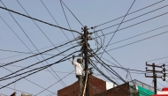 A worker repairs a street light in Varanasi on May 22, 2026. (Photo by Niharika KULKARNI / AFP)