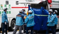 A person is taken on a stretcher to an ambulance by paramedics at the Ginza 6 Shopping Center in Tokyo on May 25, 2026, after an individual allegedly sprayed a substance in the area. (Photo by Andrew Caballero-Reynolds / AFP) 