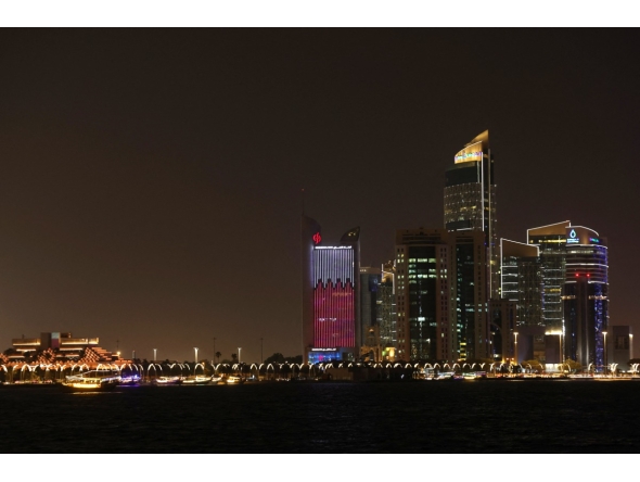 Illuminated skyscrapers are pictured along the corniche promenade in Doha on May 15, 2026. Photo by Karim JAAFAR / AFP