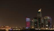 Illuminated skyscrapers are pictured along the corniche promenade in Doha on May 15, 2026. Photo by Karim JAAFAR / AFP