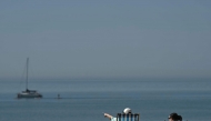 People relax in deck chairs on the beach in Brighton, on the south coast of England on May 25, 2026, as Monday is expected to be the hottest bank holiday ever, with heatwave conditions spreading to parts of southeast England and London. (Photo by Ben STANSALL / AFP)