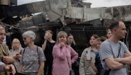 Local residents stand by a damaged shopping center following Russian strikes in Kyiv on May 25, 2026. (Photo by Tetiana Dzhafarova / AFP)